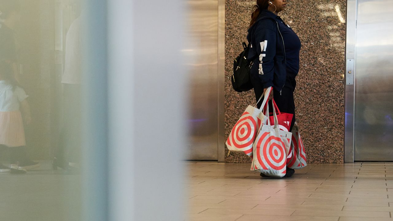A shopper carries Target bags outside a store in the Queens borough of New York, US, on Monday, May 15, 2023. 