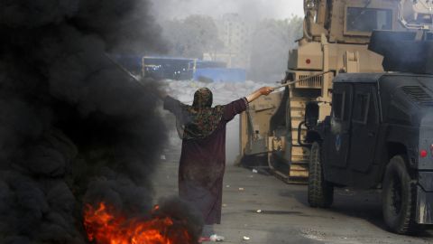 A woman tries to stop a military bulldozer during clashes that broke out as Egyptian security forces dispersed supporters of deposed president Mohamed Morsy in a huge protest camp near Rabaa al-Adawiya mosque in Cairo on August 14, 2013. 