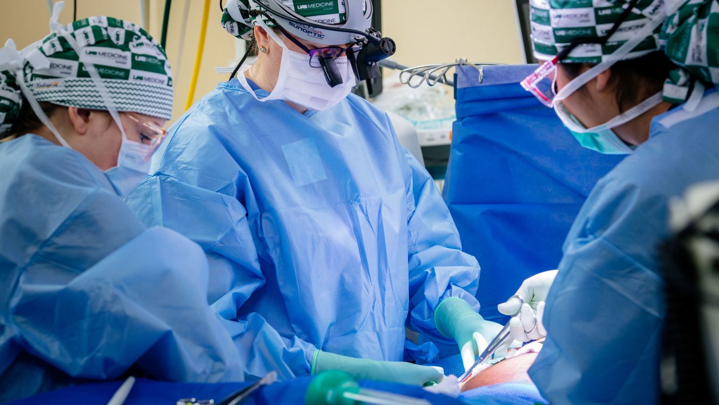 From left:: Sandi Minor, RN, Registered Nurse, Perioperative Services; Dr. Jayme Locke, MD, , Director, UAB Division of Transplantation; and Natalie Budd, RN, Registered Nurse, Perioperative Services, biopsy a genetically modified pig kidney as part of UAB's 2023 JAMA Surgery study.