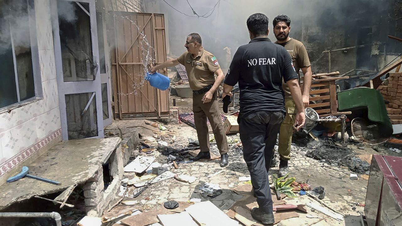 Police inspect a house that was set on fire in a Christian neighborhood in Jaranwala on Wednesday. 