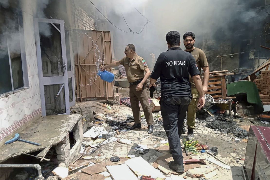 Police inspect a house that was set on fire in a Christian neighborhood in Jaranwala on Wednesday.