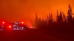 A vehicle is parked near a burning wildfire in Hay River, Canada August 15, 2023 in this screengrab obtained from a social media video. Morgan Monkman/via REUTERS  THIS IMAGE HAS BEEN SUPPLIED BY A THIRD PARTY. MANDATORY CREDIT. NO RESALES. NO ARCHIVES.