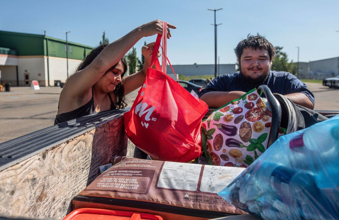 Canadian fire evacuees Tanisha Edison and her boyfriend Mason Bruneau go through their belongings at the evacuee center in St. Albert, Alberta, on August 16.