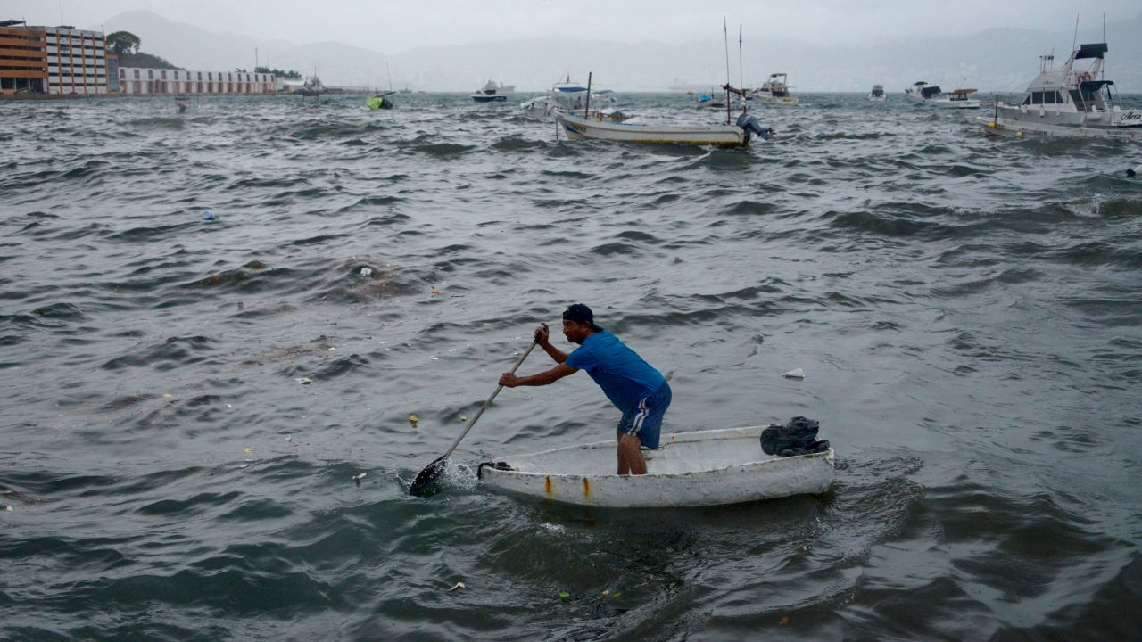 A man rows his boat in Acapulco in the Mexican state of Guerrero on August 16, following the passage of Tropical Storm Hilary.