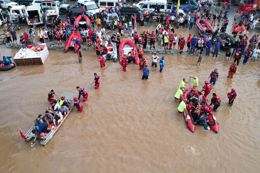 Rescuers use rubber boats to transfer Zhuozhou residents trapped by flood waters after days of downpours brought by Typhoon Doksuri on August 2.