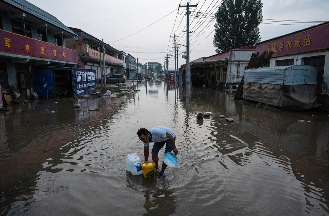 A man wades through receding floodwaters in a street in Zhuozhou on August 5.