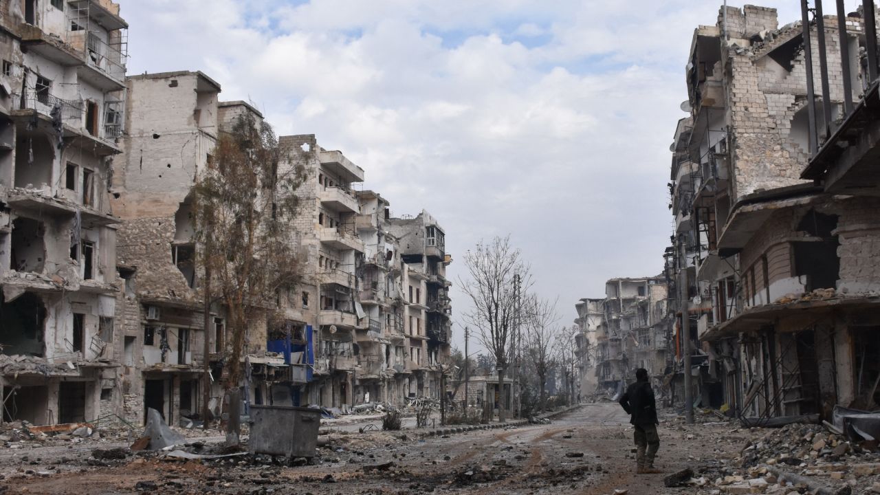 A member of the Syrian regime forces stands amidst destruction in the former rebel-held Sukkari district in Aleppo on December 23, 2016. The city was one of the hardest-hit areas of the civil war. 