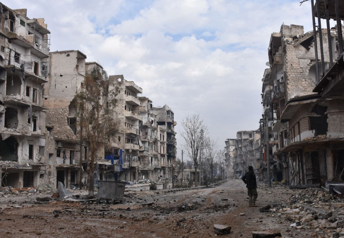 A member of the Syrian regime forces stands amidst destruction in the former rebel-held Sukkari district in Aleppo on December 23, 2016. The city was one of the hardest-hit areas of the civil war. 