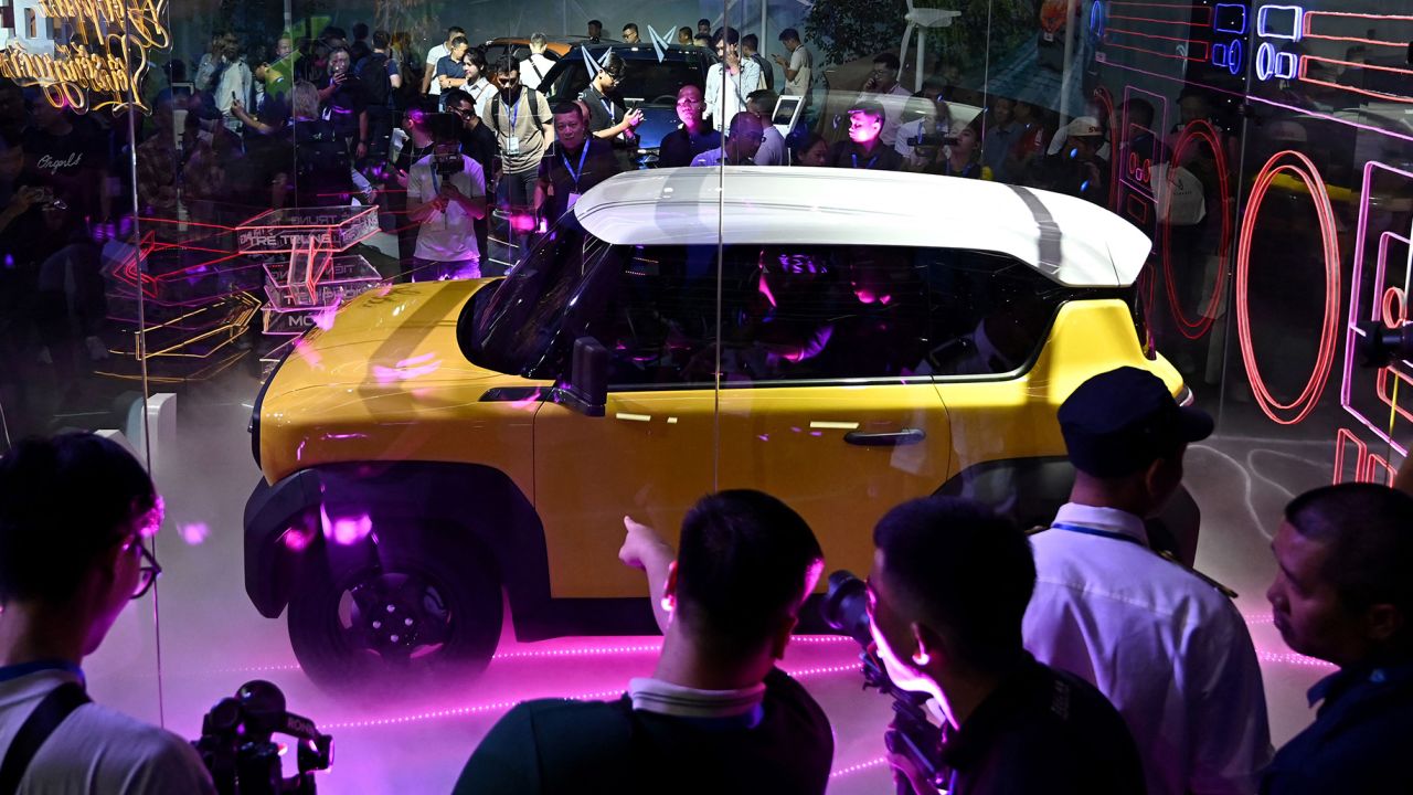 People look at an electric car displayed during the launch of VinFast electric car models in Hanoi on July 7, 2023. 