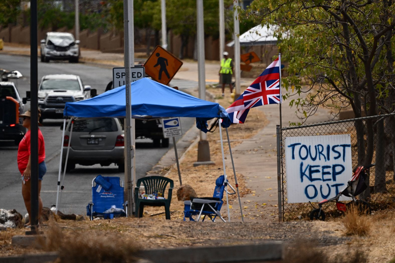 The state flag of Hawaii flies over a sign in Lahaina that says "tourist keep out" on August 16. <a href="index.php?page=&url=https%3A%2F%2Fwww.cnn.com%2Fvideos%2Fworld%2F2023%2F08%2F17%2Fexp-maui-tourists-wildfires-lee-intvw-081712aseg2-us.cnn" target="_blank">Vacationers are being asked to stay home</a> as Maui recovers. Many hotels are housing evacuees.