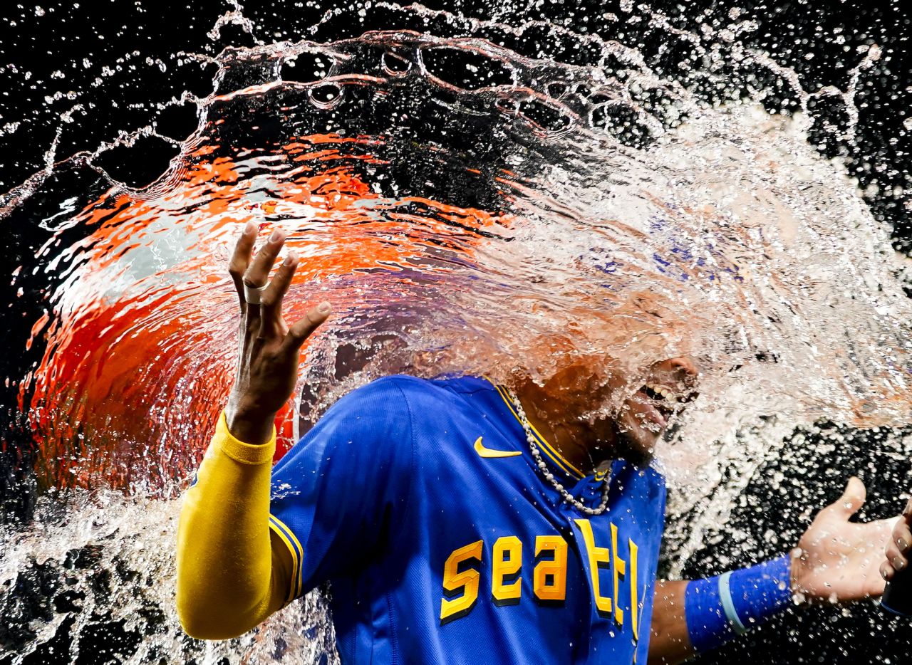 Seattle Mariners center fielder Julio Rodríguez is doused by teammate Teoscar Hernández after a win over Baltimore on Friday, August 11.