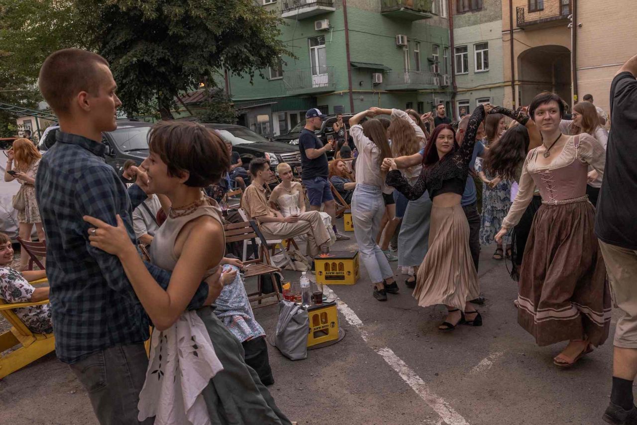 Local residents dance while musicians plays folk music at a yard bar in Kyiv, Ukraine, on Sunday, August 13.