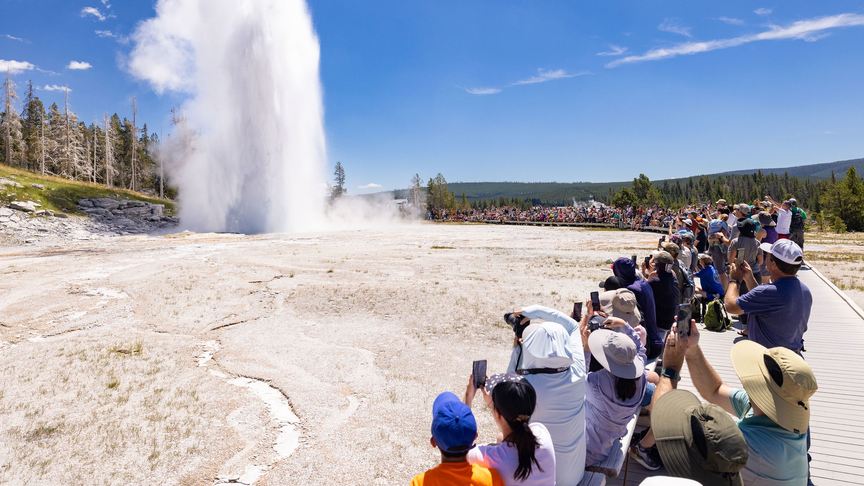 Crowds watch summer Grand Geyser eruption at Yellowstone National Park on July 19, 2023.