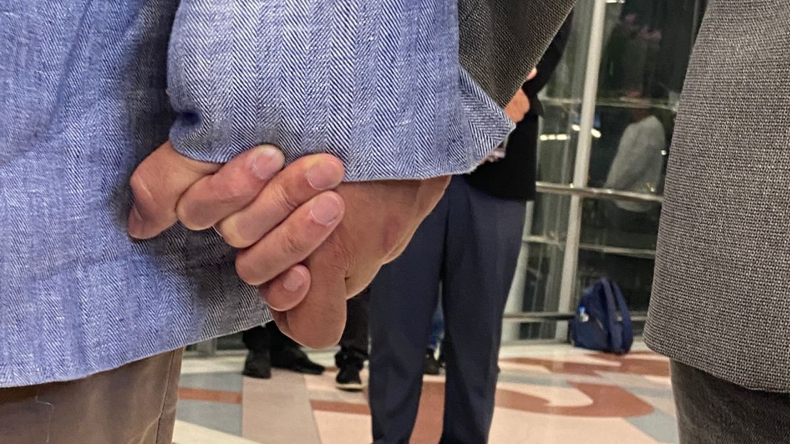 Vacharaesorn and Chakriwat Vivacharawongse hold hands during their press conference at Bangkok airport.