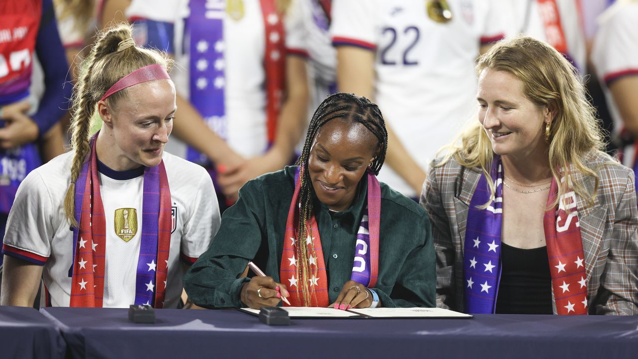 Crystal Dunn (middle) signs a collective bargaining agreement signing signifying equal pay between the US men's and women's national soccer teams on September 6, 2022 in Washington, DC. 