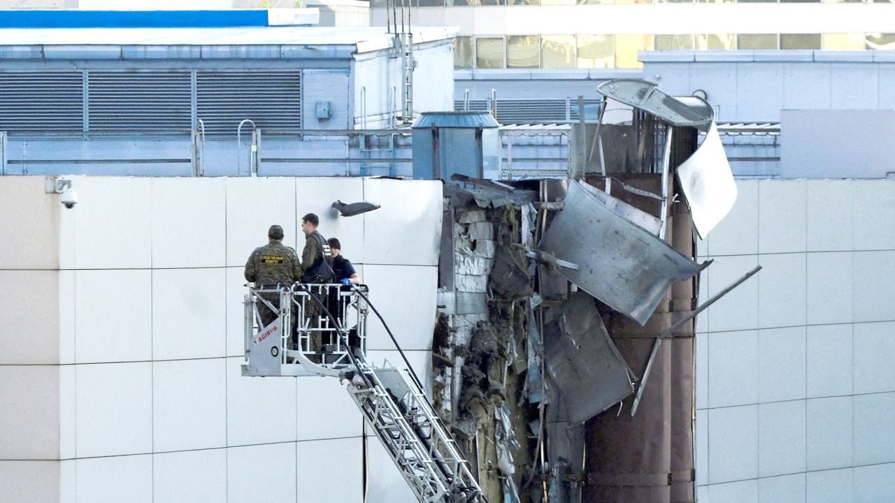 Investigators work near a damaged roof following a reported shooting down of a drone in Moscow, Russia.