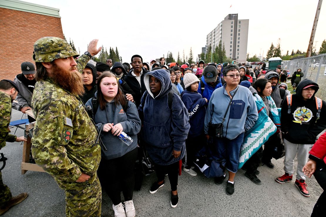 People line up outside a school to be evacuated in Yellowknife.     