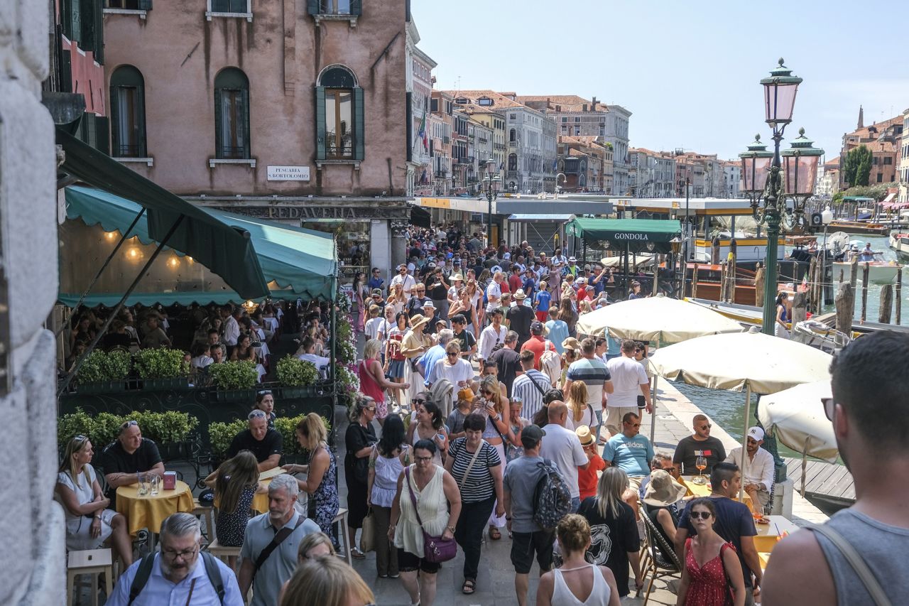 VENICE, ITALY - AUGUST 02: Tourists crowd the area near the Rialto Bridge on August 02, 2023 in Venice, Italy. UNESCO officials have included Venice and its lagoon to the list of world heritage in danger to review, along with Ukraine's Kyiv, and Lviv. The UN cultural agency deems Italy not effective in protecting Venice from mass tourism and extreme weather conditions. (Photo by Stefano Mazzola/Getty Images)