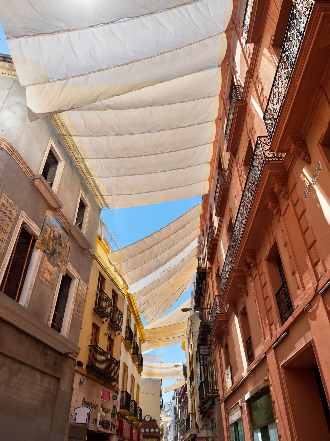 Cloth awnings protect shoppers and pedestrians from the fierce summer sun in Calle Sierpes, a shopping street in Seville, Spain.
