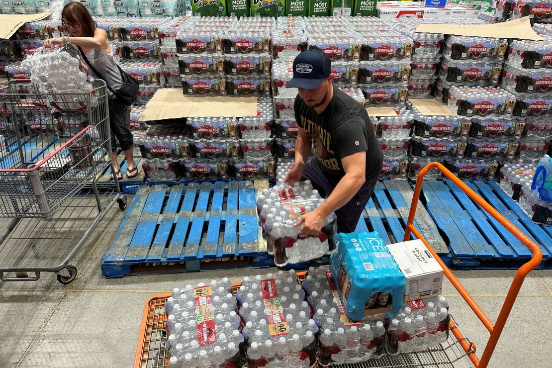 An Instacart delivery driver loads cases of bottled water as people buy emergency supplies ahead of Hurricane Hilary at a Costco warehouse in Hawthorne, California, on August 19, 2023.