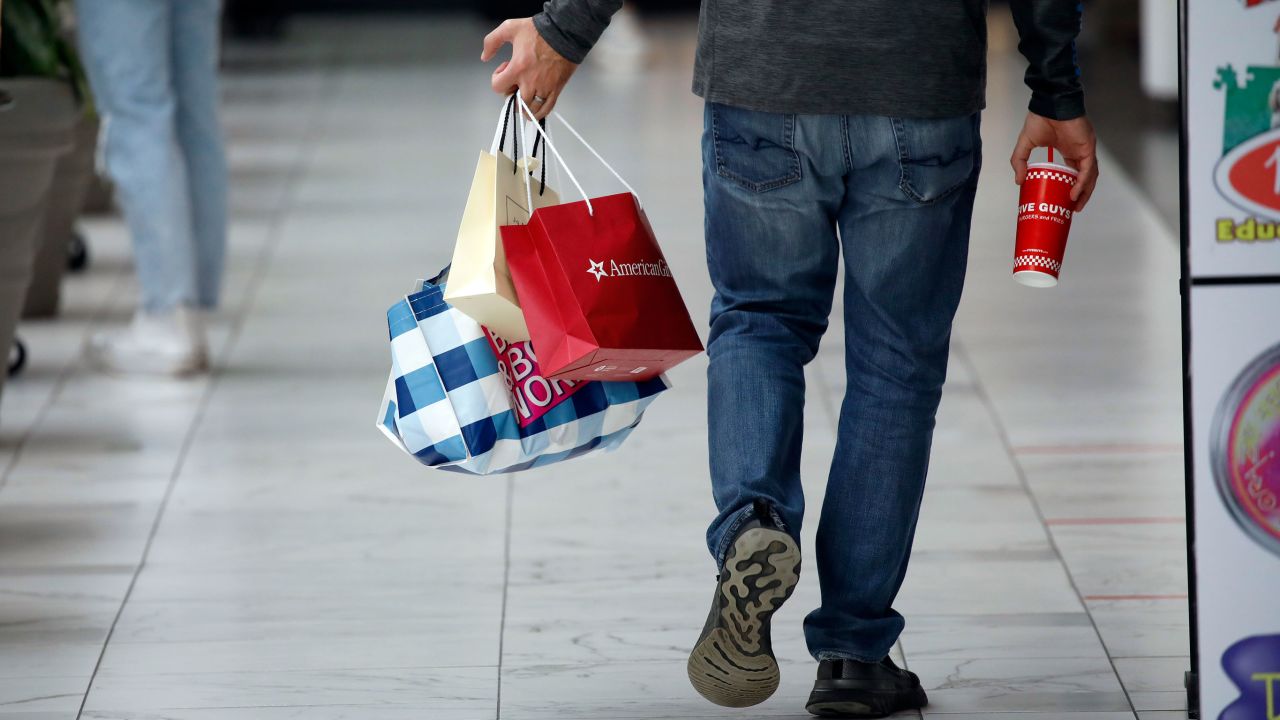 A shopper carries retail bags while walking through a shopping mall in Columbus, Ohio, U.S., on Friday, Dec. 10, 2021.