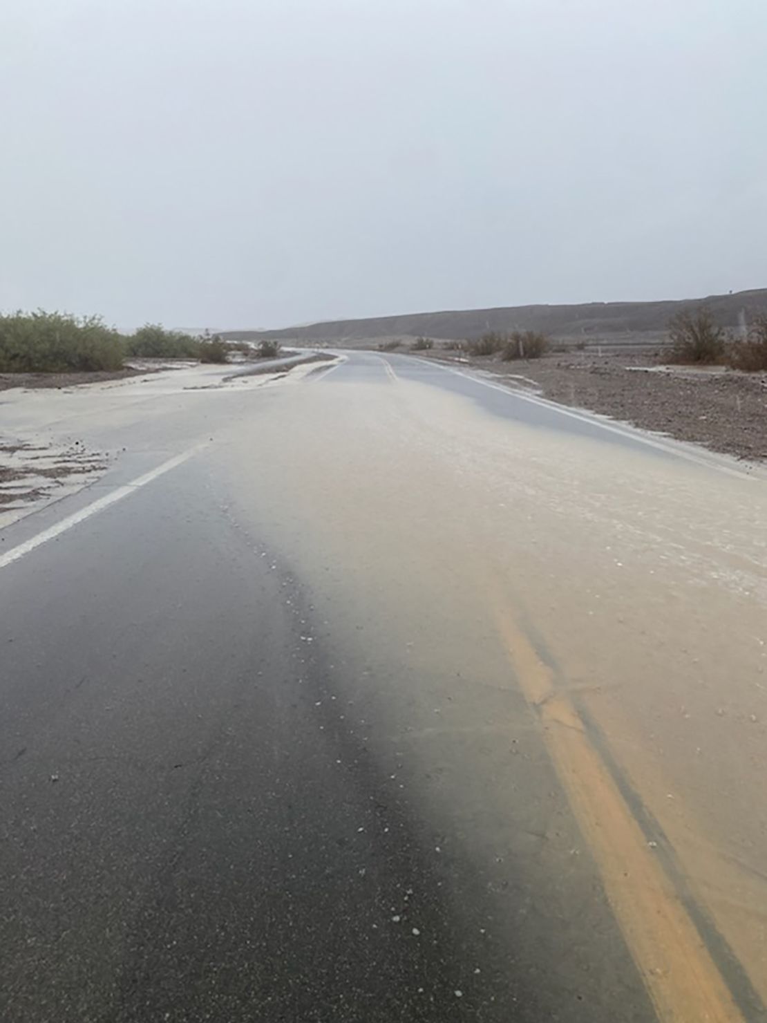 Floodwaters from Tropical Storm Hilary cover a road in Death Valley National Park on Sunda.