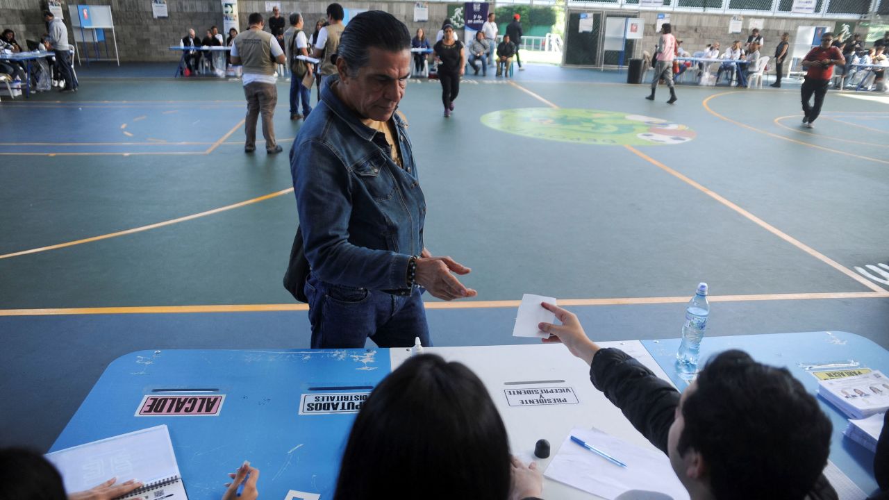 A voter casts their ballot at a polling station during the presidential run-off election in Guatemala City, Guatemala, on August 20, 2023.