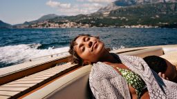 Young woman resting with boyfriend in speedboat during summer vacation