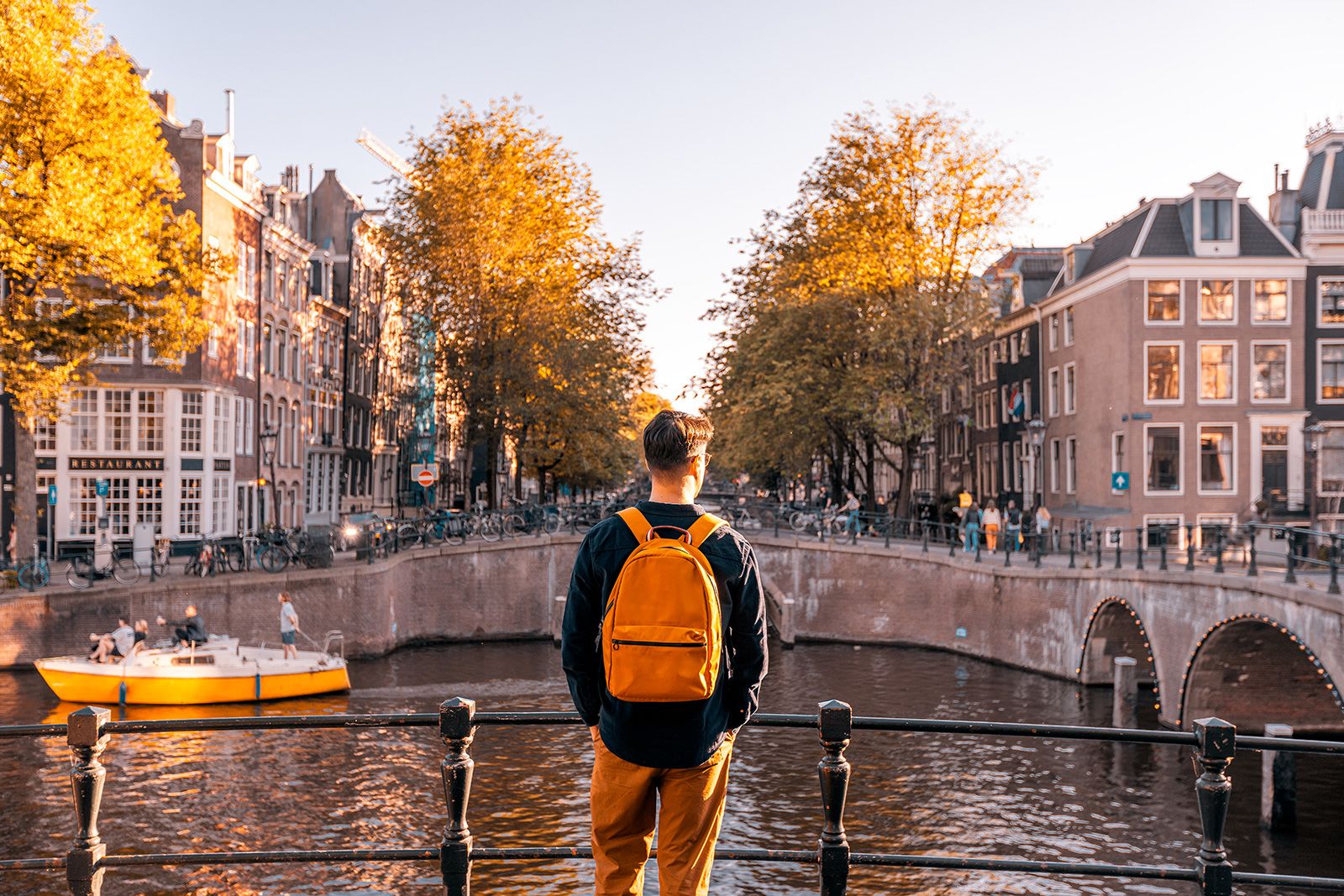 Rear view of a man looking at Amsterdam canal on a sunny day, Netherlands