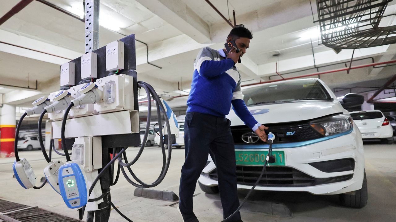 A man charging an EV at a BluSmart charging hub in Gurugram, India, in December 2022. BluSmart is an Indian ride-hailing startup that uses an all-electric fleet, relying heavily on charging infrastructure.