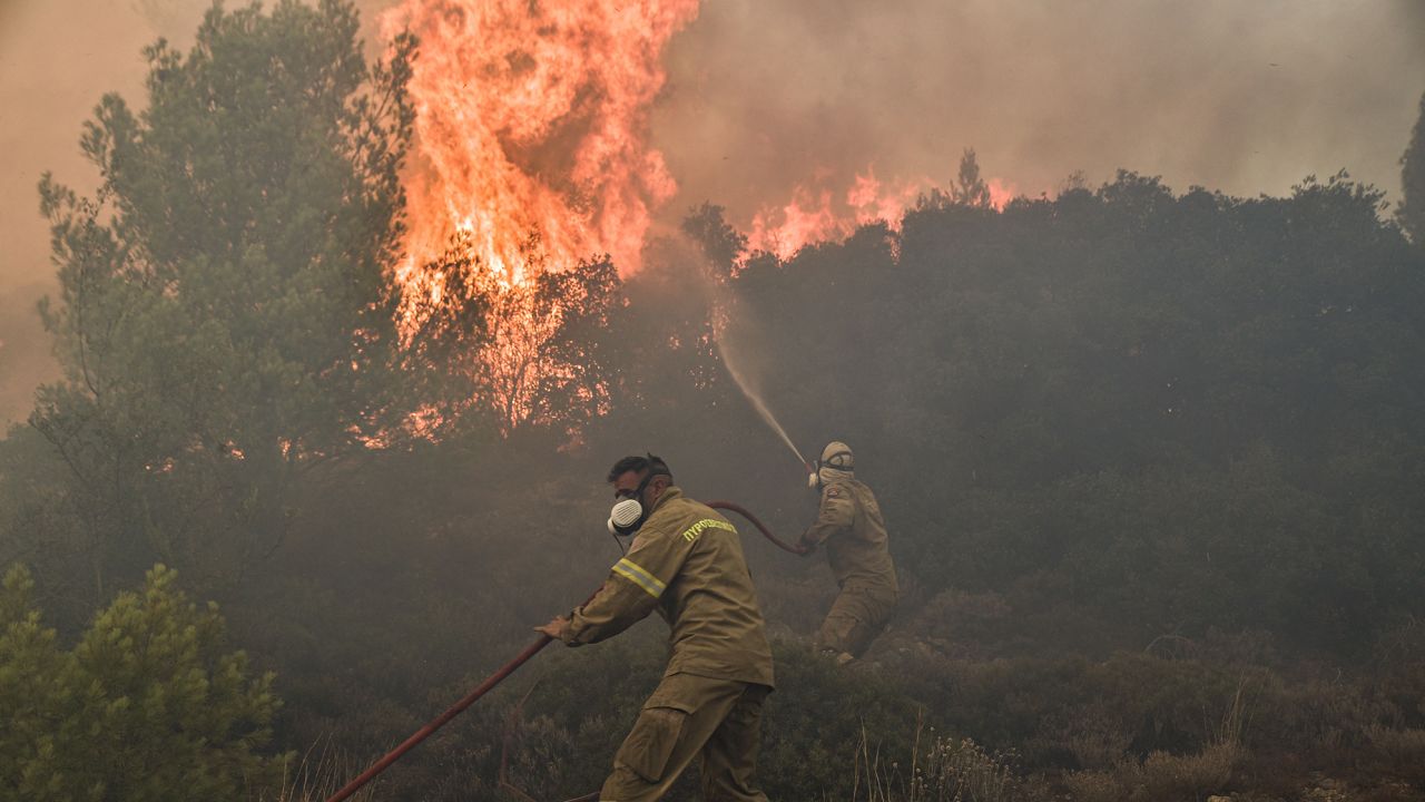 Firefighters battle flames during a wildfire near Prodromos on August 21, 2023.