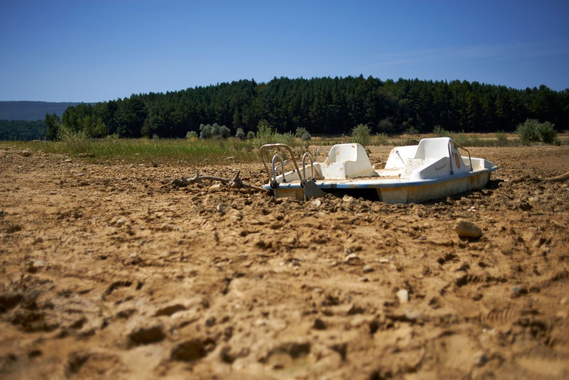 A paddleboat lies in the mud of the Montbel's lakebed, on August 18, 2023. Montbel is well below its normal level due to an unprecedented drought.