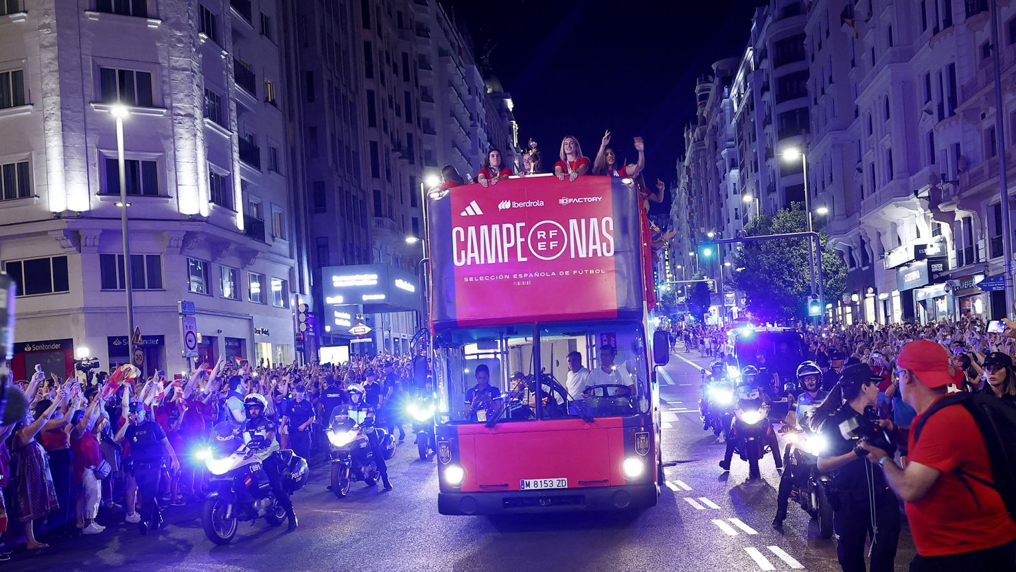 An open-top bus carries Spain's conquering heroes through the streets of Madrid.