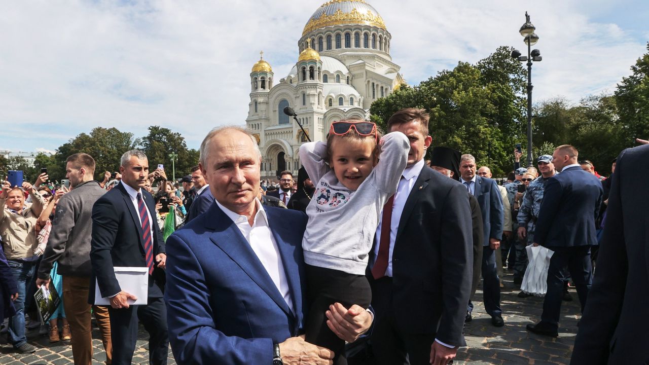 Russia's President Vladimir Putin holds a child during his meeting with local residents in front of The Naval Cathedral of Saint Nicholas in Kronstadt, on Kotlin Island, outside Saint Petersburg, on July 23, 2023. Putin and his Belarus counterpart met a crowd of people in Kronstadt, in a rare walkabout for the longtime leaders a month after a deal to end a dramatic Wagner munity in Russia. (Photo by Alexandr Demyanchuk / SPUTNIK / AFP) (Photo by ALEXANDR DEMYANCHUK/SPUTNIK/AFP via Getty Images)