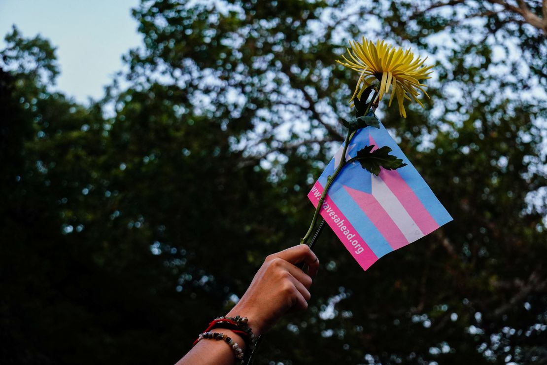 A person holds a transgender pride flag and a flower during a Black Trans Liberation protest in New York, United States, May 31, 2023. REUTERS/Amr Alfiky
