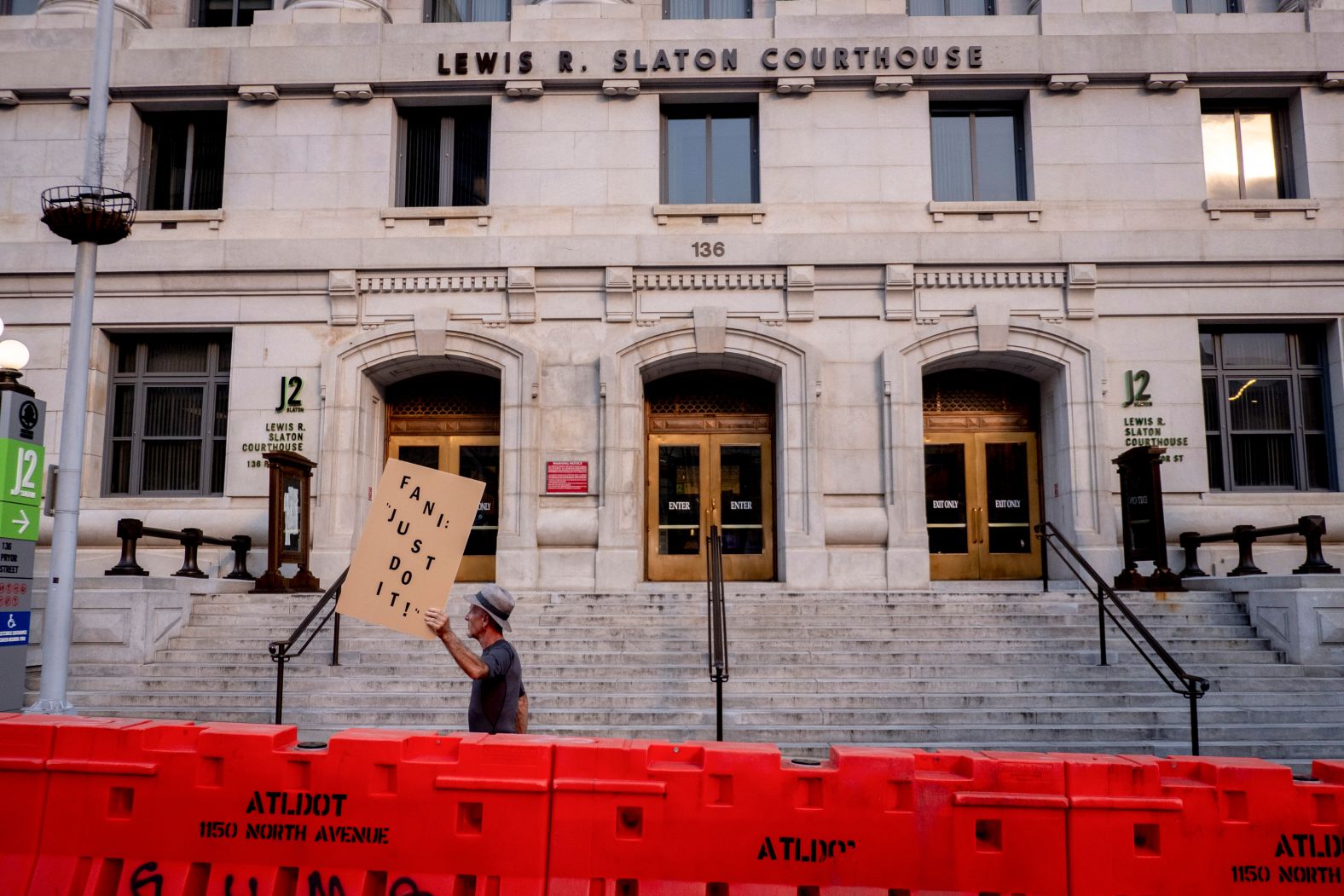 A protester carries a sign saying "Fani: Just do it!" outside the courthouse on August 14.