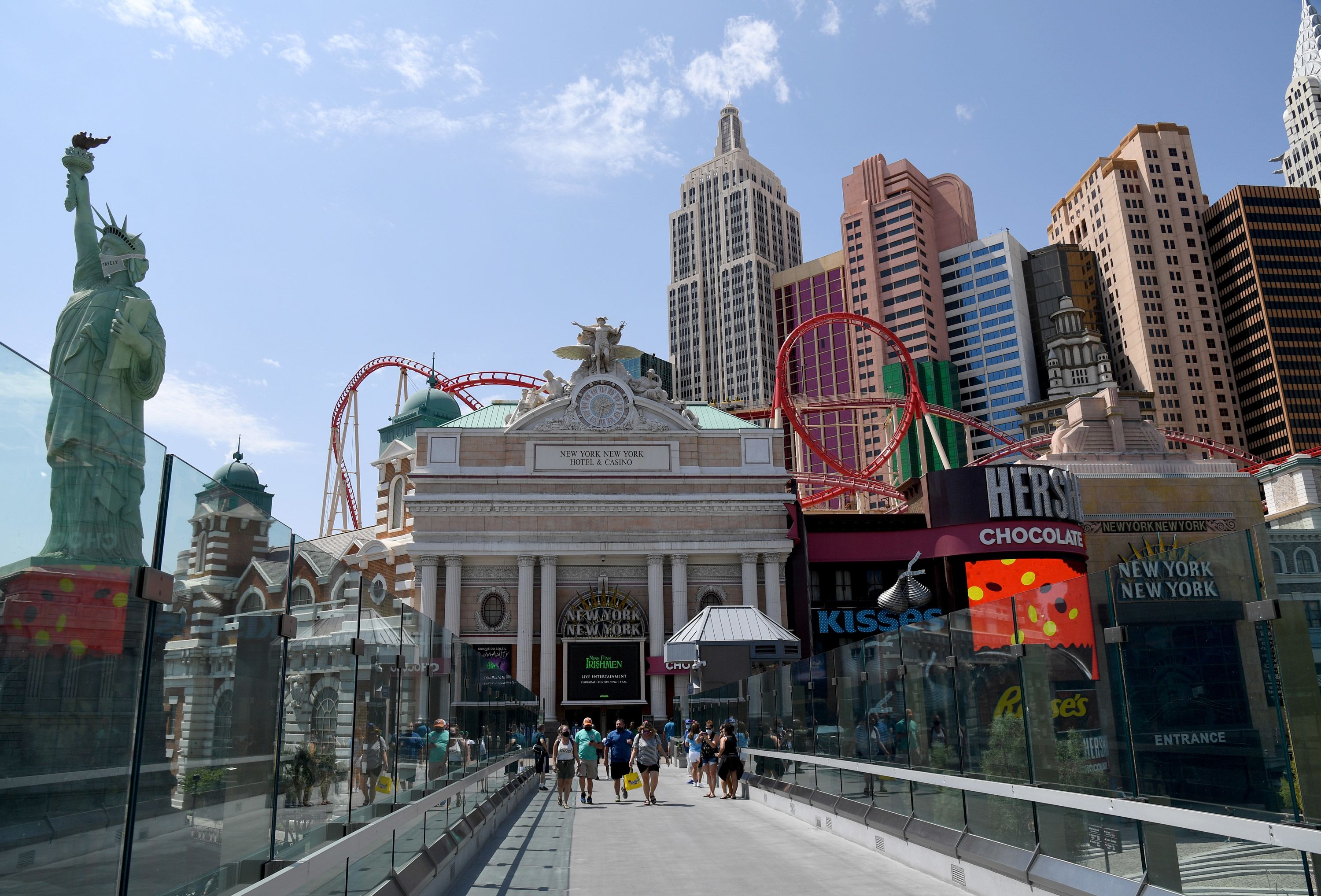 LAS VEGAS, NEVADA - AUGUST 28: Visitors walk on a pedestrian bridge between MGM Resorts International properties New York-New York Hotel & Casino and MGM Grand Hotel & Casino on the Las Vegas Strip amid the spread of coronavirus (COVID-19) on August 28, 2020 in Las Vegas, Nevada. MGM Resorts International will lay off 18,000 furloughed employees in the United States on Monday as the resort industry struggles to recover from the pandemic. The move was necessary since federal law requires companies to lay off furloughed workers after six months. Before hotel-casinos shut down in March, the company had 68,000 employees nationwide, including 52,000 in Las Vegas. MGM Resorts said laid-off employees could be brought back as business demand returns. (Photo by Ethan Miller/Getty Images)