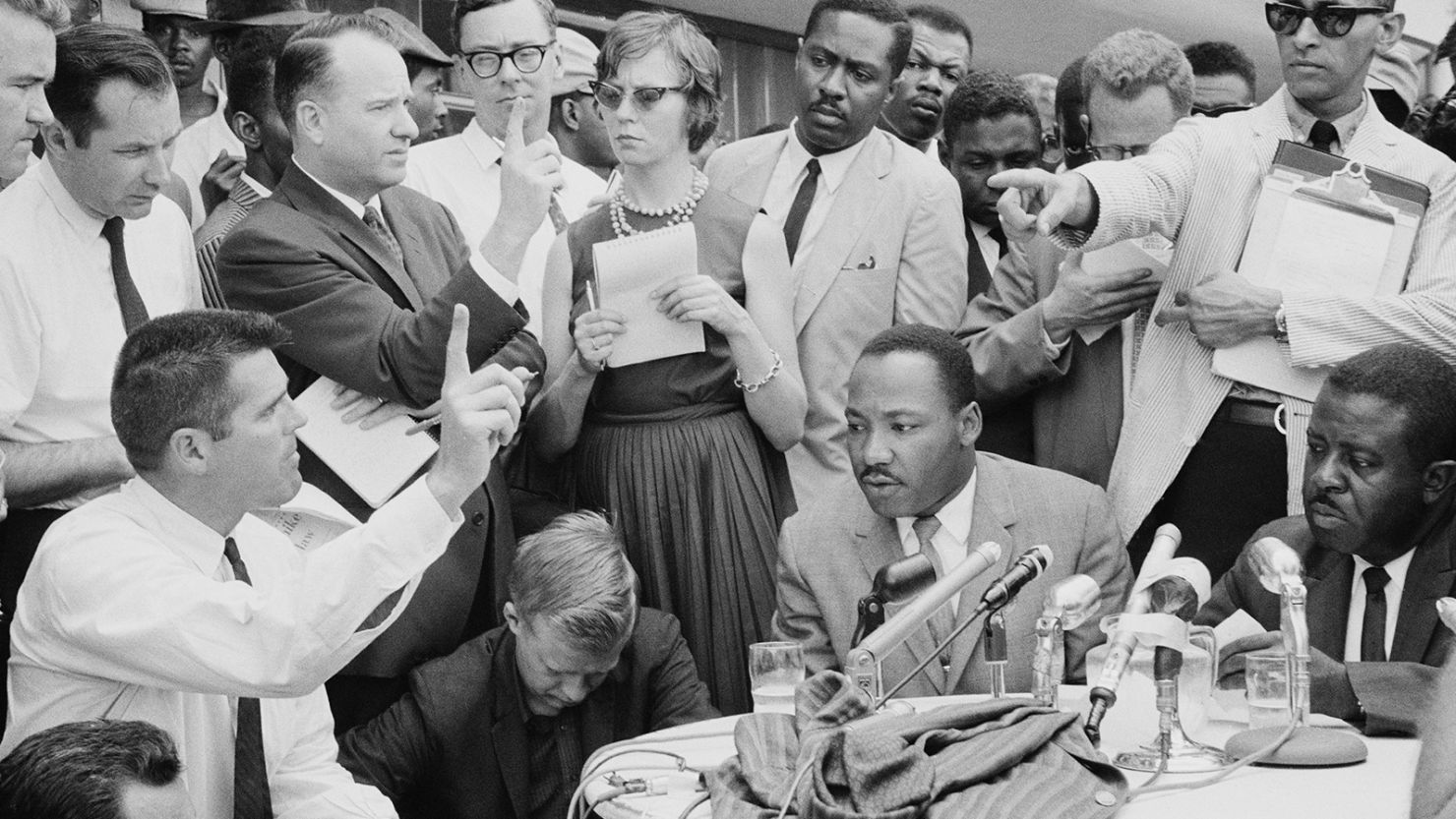 American Baptist minister and civil rights leader Martin Luther King Jr (1929 - 1968, seated, centre-right) gives a press conference regarding an agreement reached on a 'limited desegregation plan' outside the A.G. Gaston Motel in Birmingham, Alabama, February 1963. Standing behind Luther King is his speechwriter Clarence B. Jones.