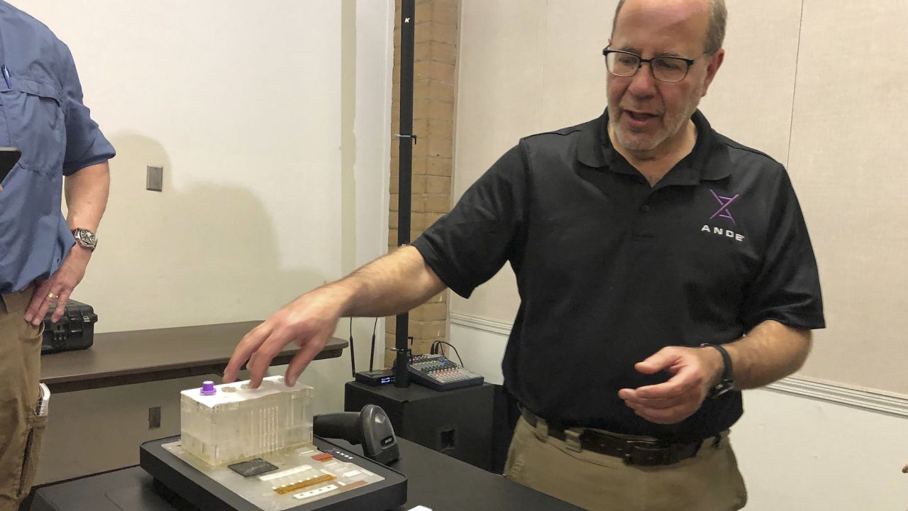 Stephen Meer, the ANDE chief information officer and managing director of critical operations, demonstrates his company's Rapid DNA analysis system in November 2018.
