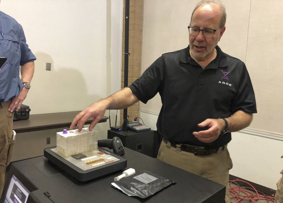 Stephen Meer, the ANDE chief information officer and managing director of critical operations, demonstrates his company's Rapid DNA analysis system in November 2018.