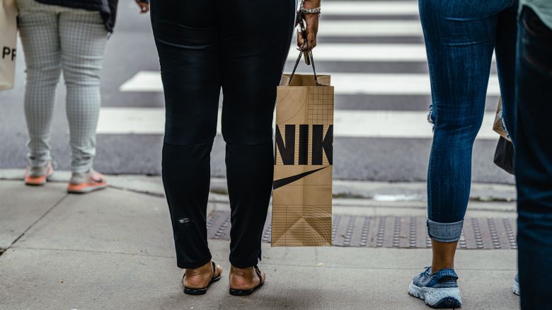 A shopper carries a Nike retail bag along the Magnificent Mile shopping district in Chicago, Illinois, US, on Tuesday, Aug. 15, 2023. US retail sales rose in July by more than forecast, suggesting consumers still have the wherewithal to sustain the economic expansion.