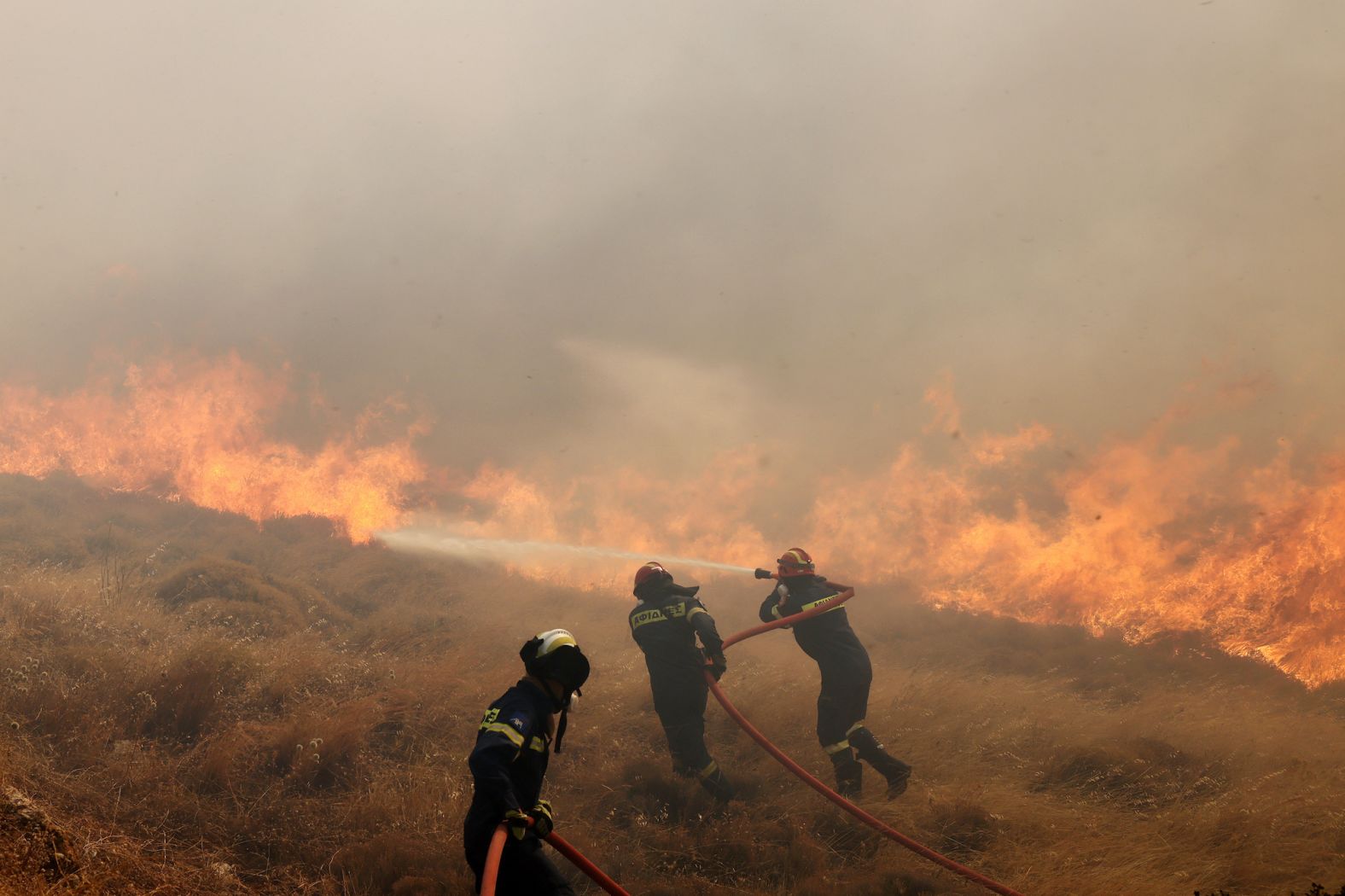 Firefighters work in the Greek village of Agia Paraskevi, near Athens, on August 23.