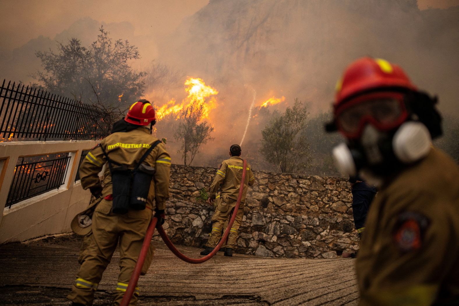 Firefighters take on a wildfire burning in Hasia on August 22.