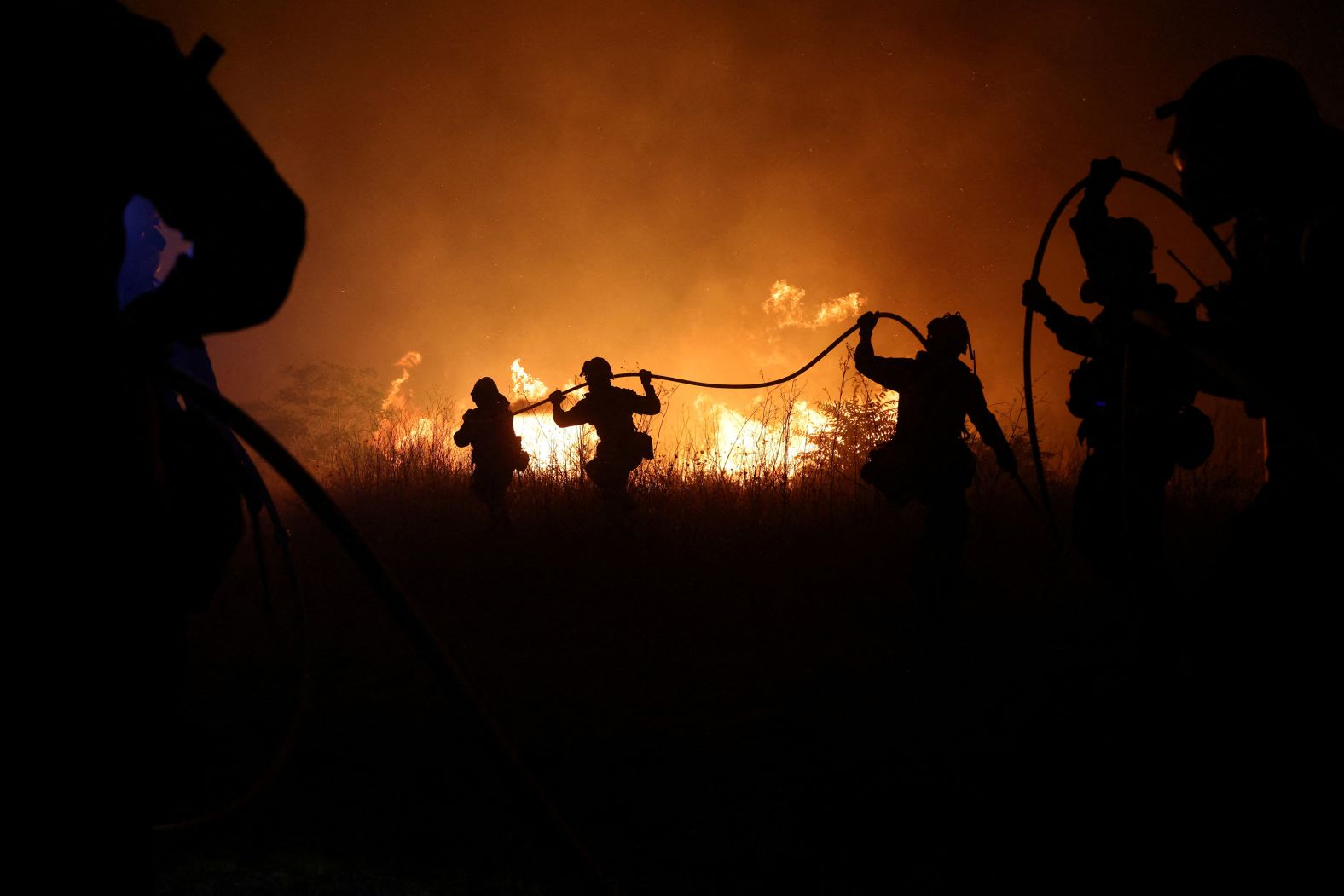 Firefighters try to extinguish a wildfire burning near the village of Makri on August 22.