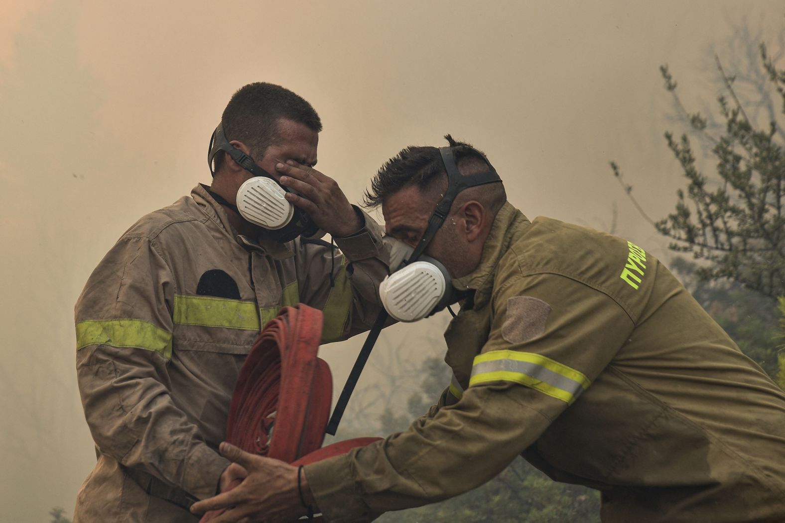 Firefighters react as they battle flames near Prodromos on Monday, August 21.