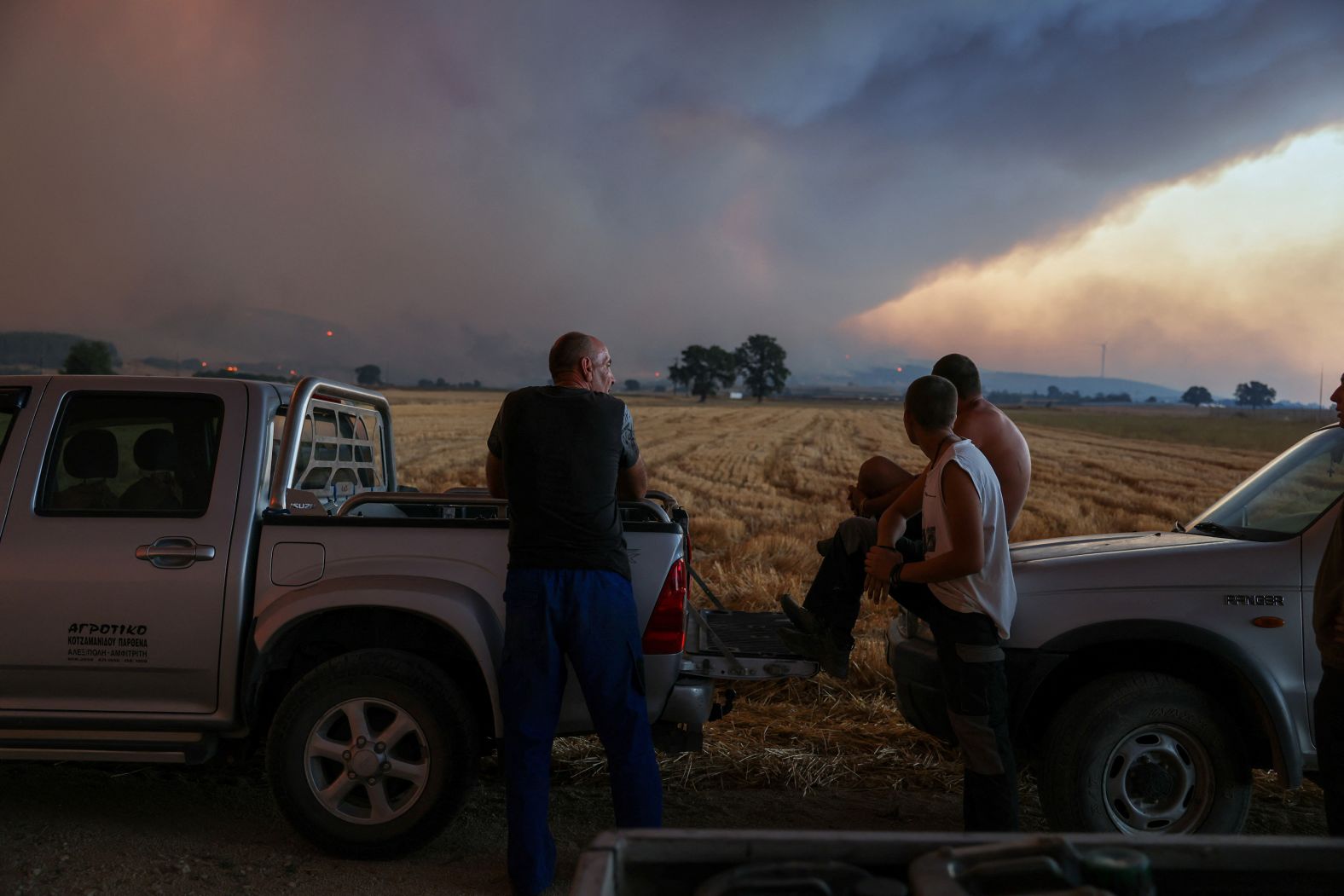 Locals watch a wildfire burning near the village of Avantas on August 21.