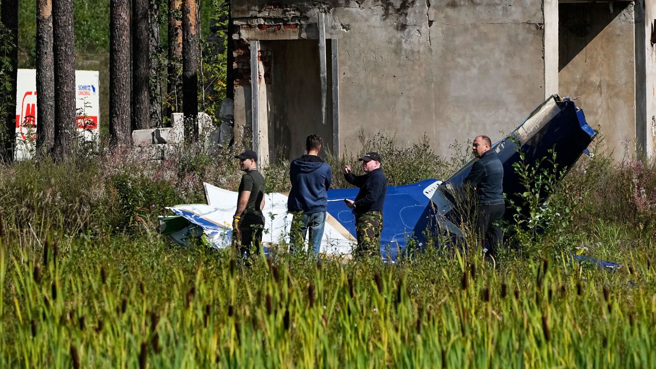 Russian servicemen inspect a part of a crashed private jet near the village of Kuzhenkino, Tver region, Russia, Thursday, Aug. 24, 2023. Russian mercenary leader Yevgeny Prigozhin, the founder of the Wagner Group, reportedly died when a private jet he was said to be on crashed on Aug. 23, 2023, killing all 10 people on board. (AP Photo/Alexander Zemlianichenko)