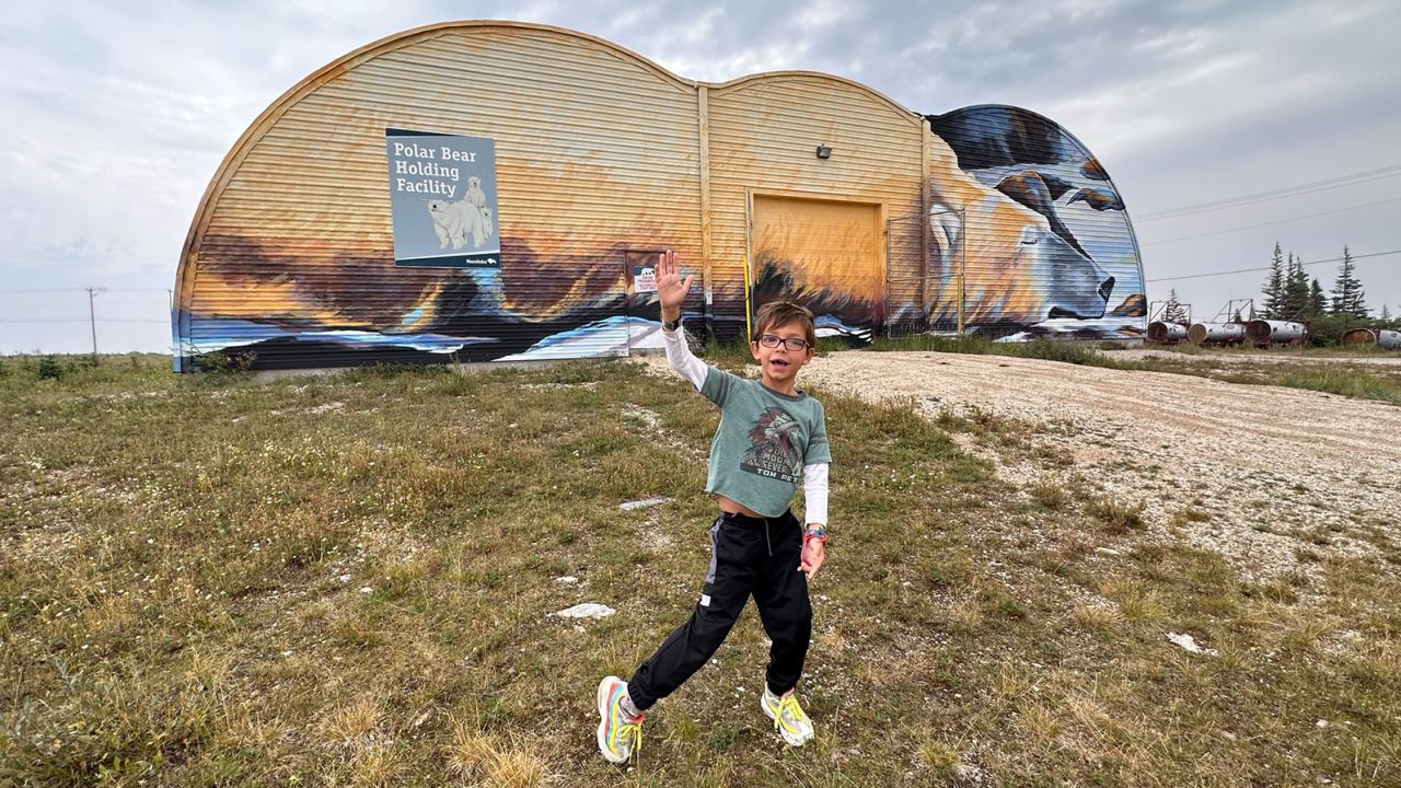 Terry Ward’s 6-year-old son stands in front of Churchill’s “Polar Bear Jail,” where nuisance bears are held before being released back into the wild.