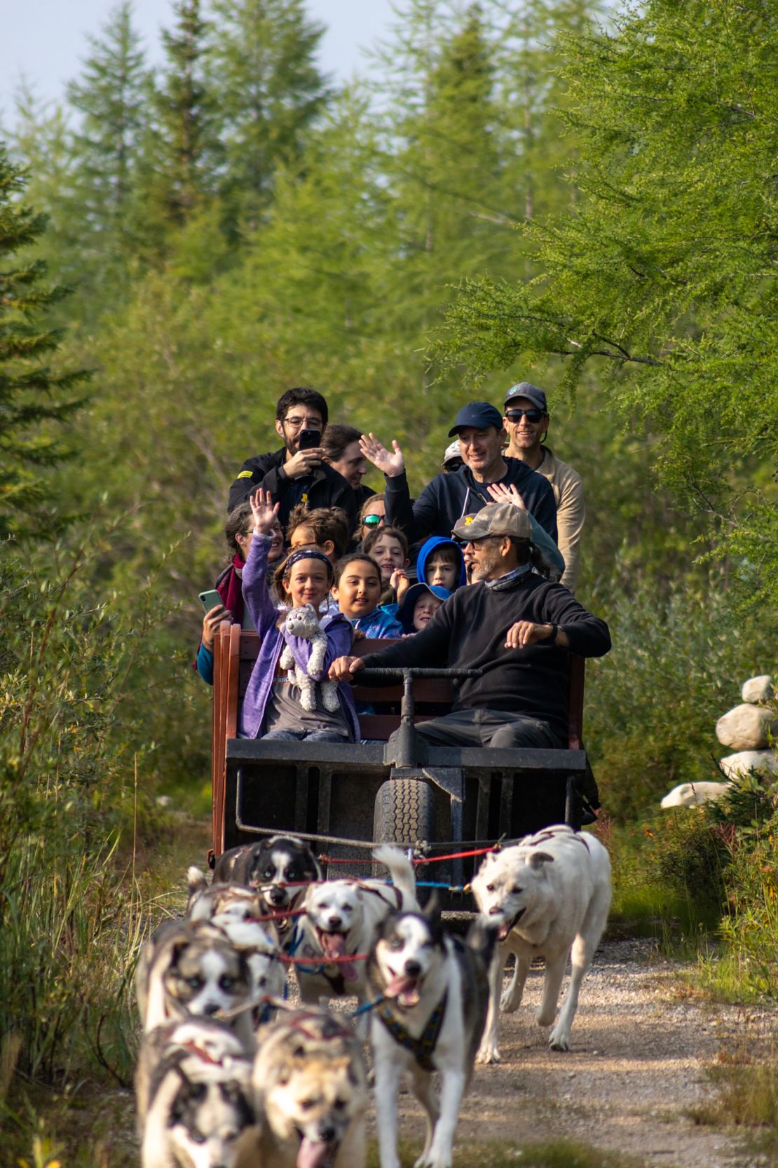 Visitors take a summertime ride behind sled dogs with Wapusk Adventures in Churchill.