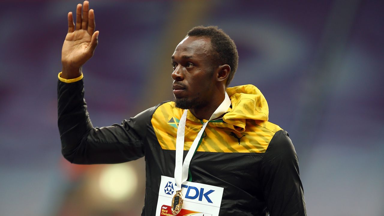 Bolt celebrates on the podium with his gold medal for the 100m at the 2013 World Championships.